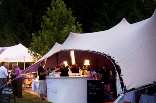 Beige Strech tent, pop up restaurant, lit up, dusk.