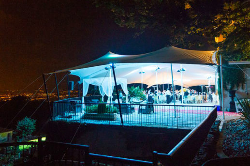 white stretch tent on a balcony lit up at night