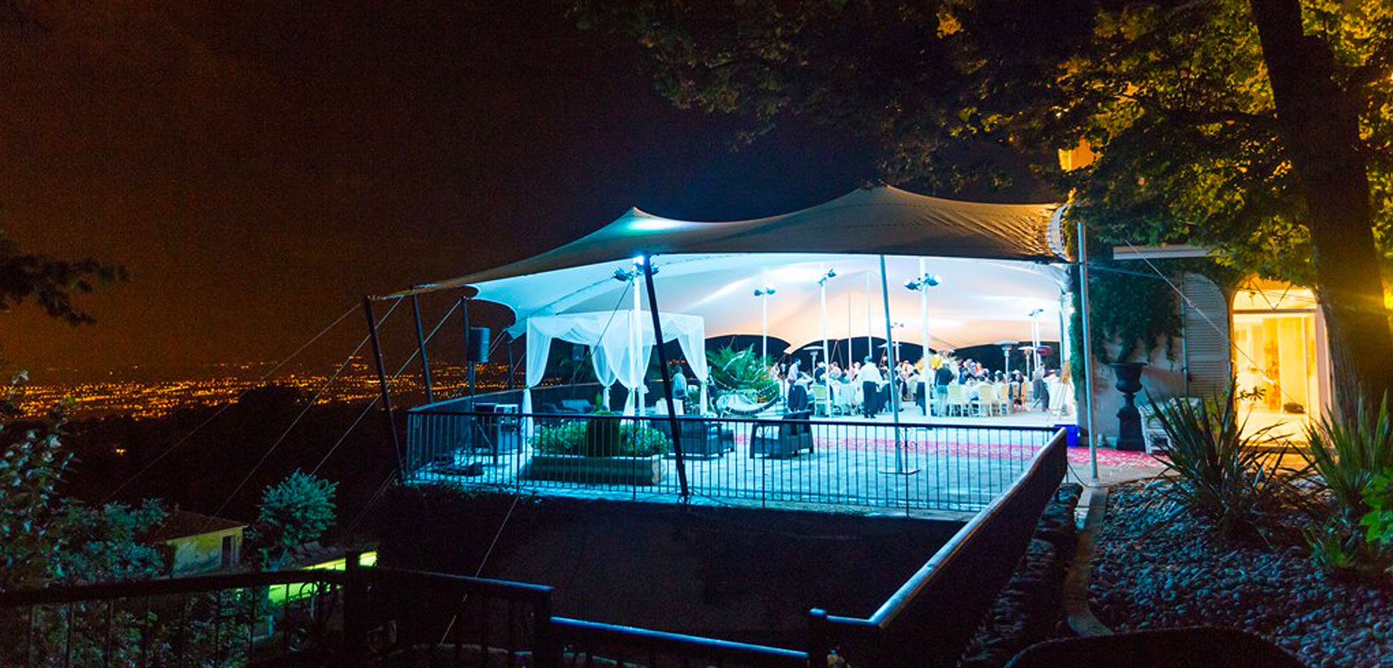 white stretch tent on a balcony lit up at night